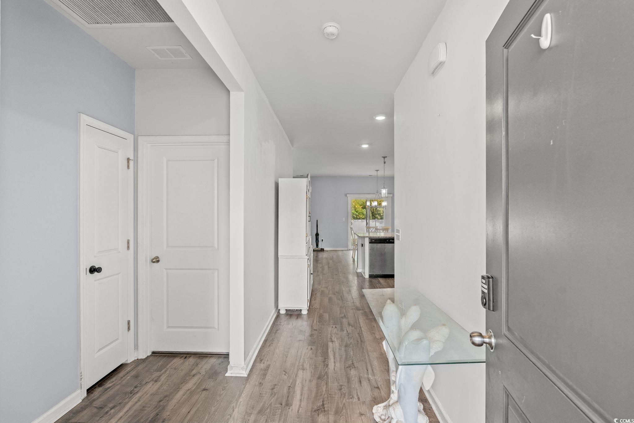 Hallway featuring wood finished floors and recessed lighting
