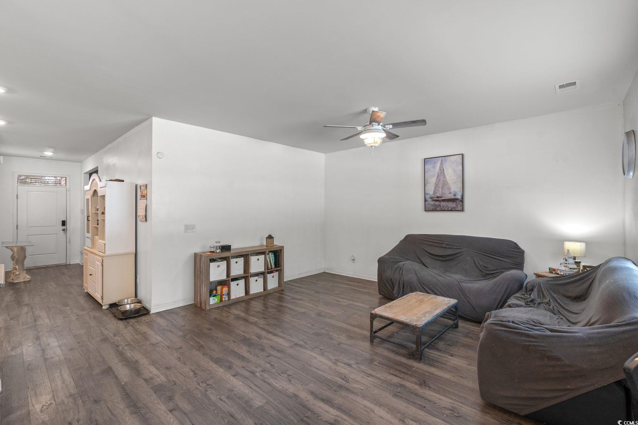 Living area featuring wood finished floors and ceiling fan