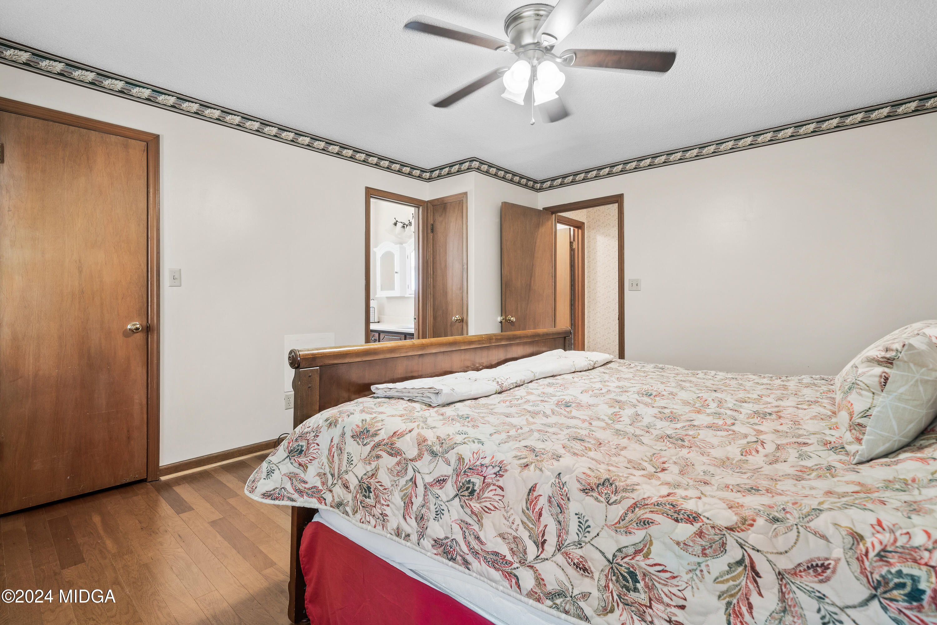 112 Whitehead Place Gray, GA 31032 - Photo 20 of 36 a bedroom with a large bed and a chandelier
