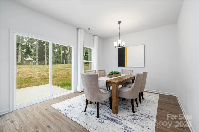 a dining room with furniture a chandelier and wooden floor
