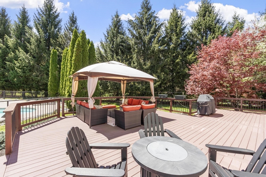 4 Ridge Road Pepperell, MA 01463 - Photo 41 of 42 a view of a patio with a dining table and chairs under an umbrella with wooden floor and fence