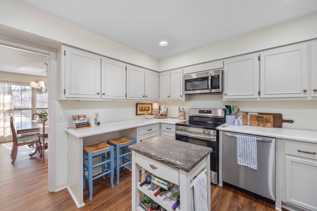 2525 Norris Road, Unit 98 Columbus, GA 31907 - Photo 10 of 40 a kitchen with stainless steel appliances granite countertop a stove top oven a sink dishwasher and white cabinets with wooden floor