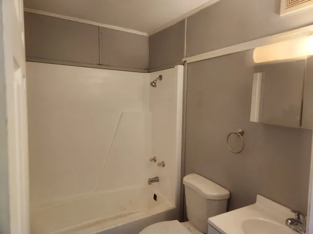 a bathroom with a toilet and a shower