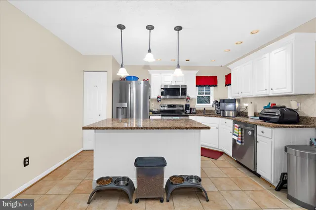 a kitchen with stainless steel appliances granite countertop a sink a stove and a wooden floors