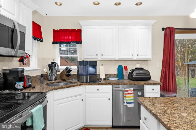 a kitchen with stainless steel appliances granite countertop a stove sink and cabinets