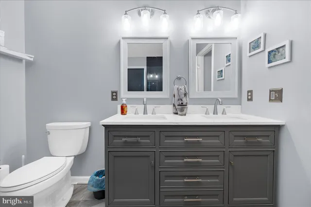 a bathroom with a toilet sink and mirror