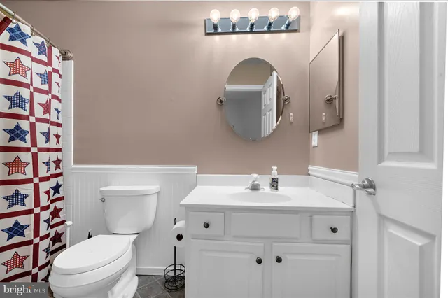 a bathroom with a sink a toilet and shower curtain