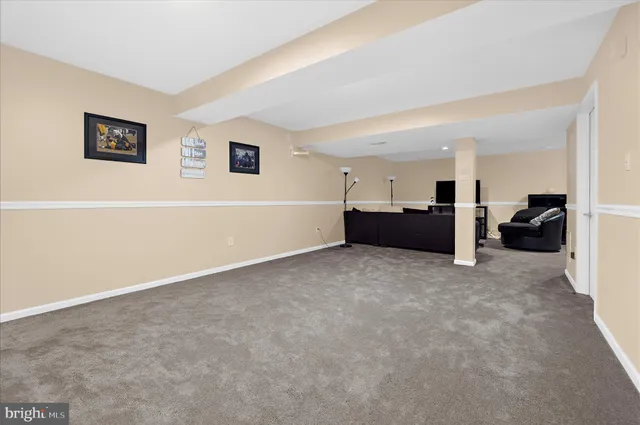 an empty room with a flat screen tv and windows