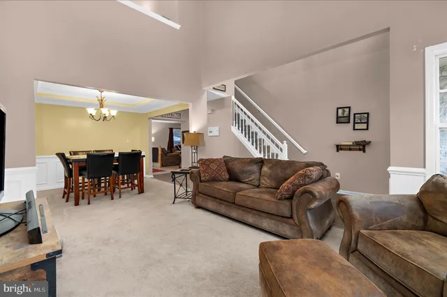 a living room with furniture and wooden dining table