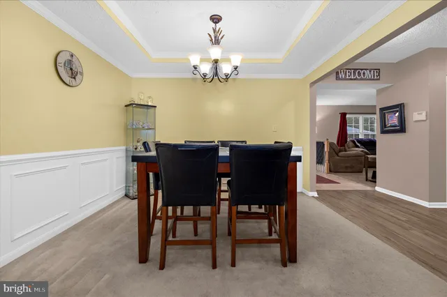 a view of a dining room with furniture and chandelier