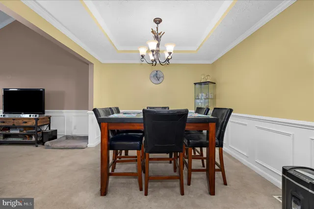 a view of a dining room with furniture and a chandelier