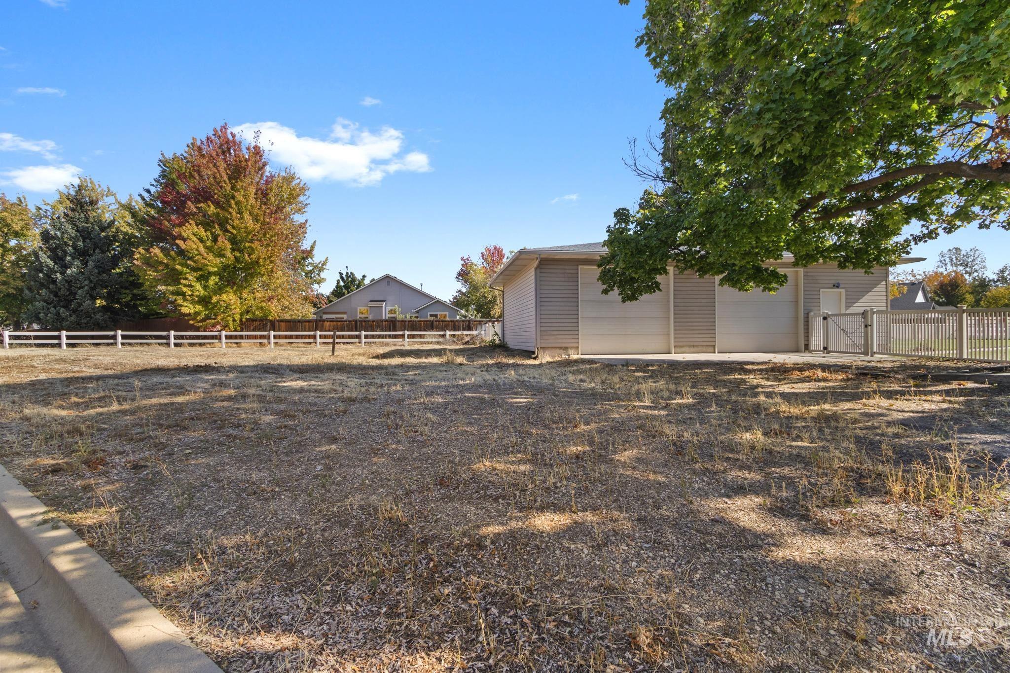 11360 West Lake Hazel Road Boise, ID 83709 - Photo 3 of 50 Expansive yard featuring a manicured lawn, brick exterior, and raised garden beds