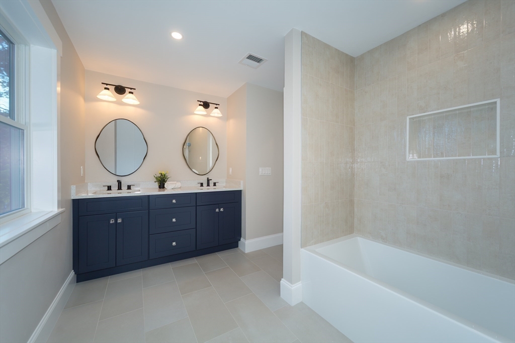 3 Ferndale Road Natick, MA 01760 - Photo 31 of 40 a bathroom with a tub a double vanity sink and a mirror