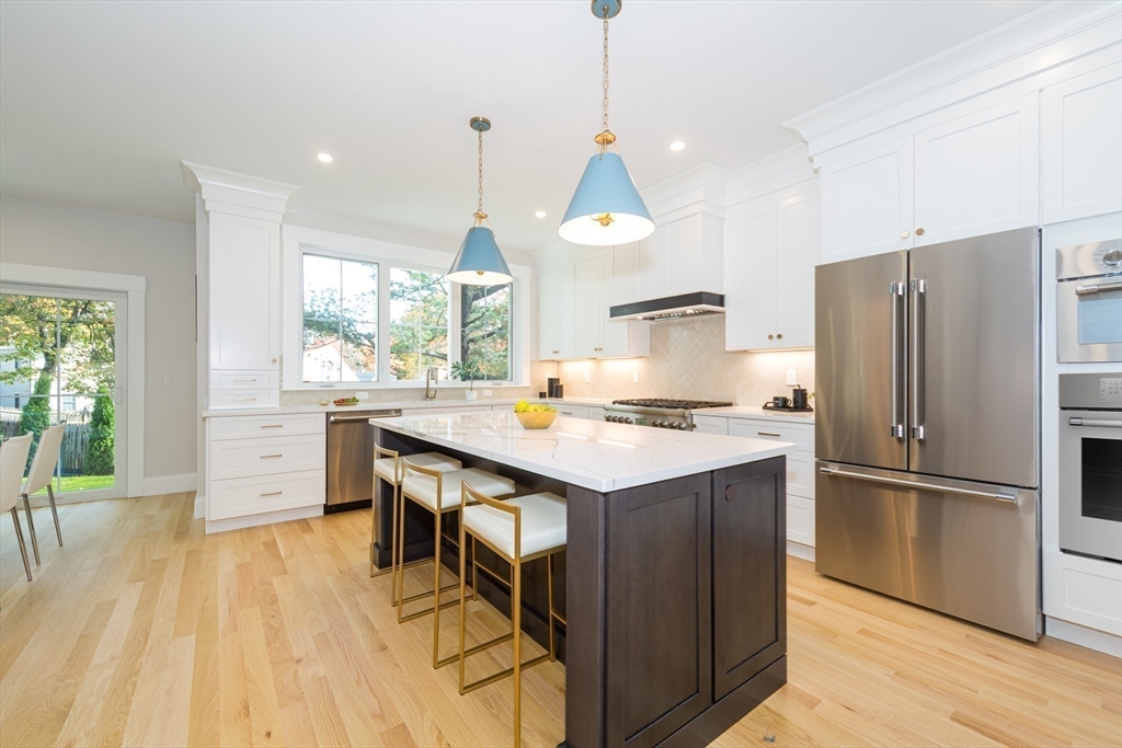 3 Ferndale Road Natick, MA 01760 - Photo 9 of 40 a kitchen with stainless steel appliances granite countertop a refrigerator a sink dishwasher a stove and white cabinets with wooden floor