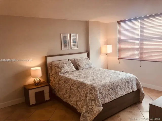 a large bed sitting in a bedroom next to a cabinet