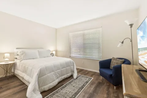 a bedroom with a bed couch and a large window