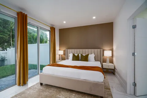 a bedroom with a large bed and a large window with outer view