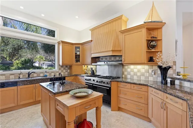 a kitchen with granite countertop a sink stove and cabinets