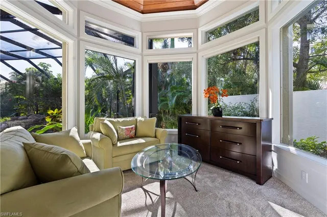 a living room with furniture and a floor to ceiling window