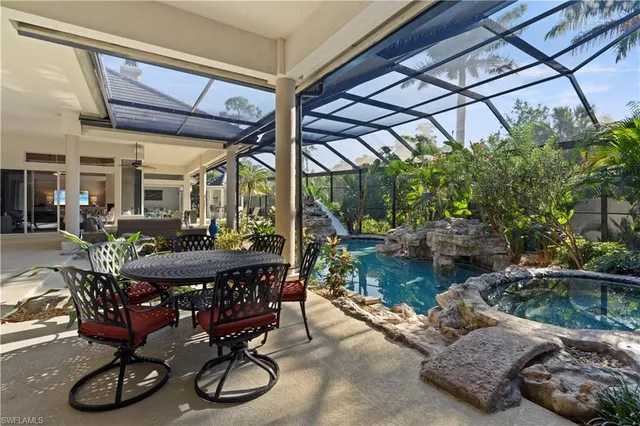 a patio with table and chairs with potted plants and couches
