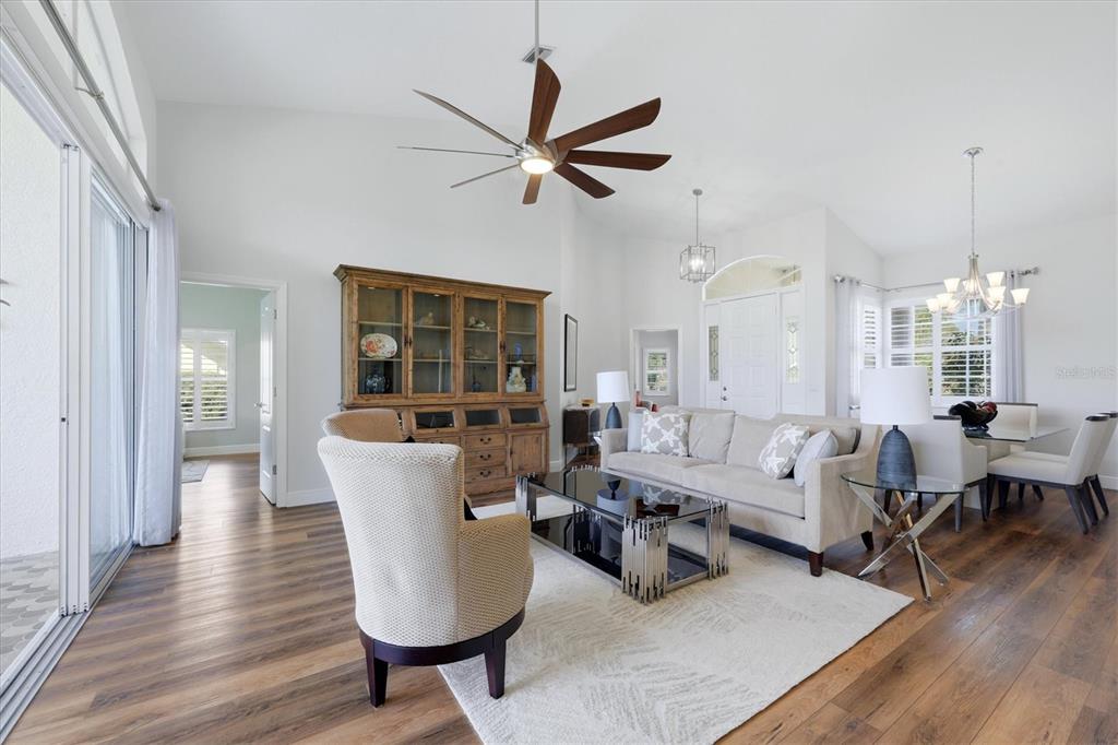 14402 Bridgeview Lane Port Charlotte, FL 33953 - Photo 14 of 93 a living room with couches a table and chairs with wooden floor