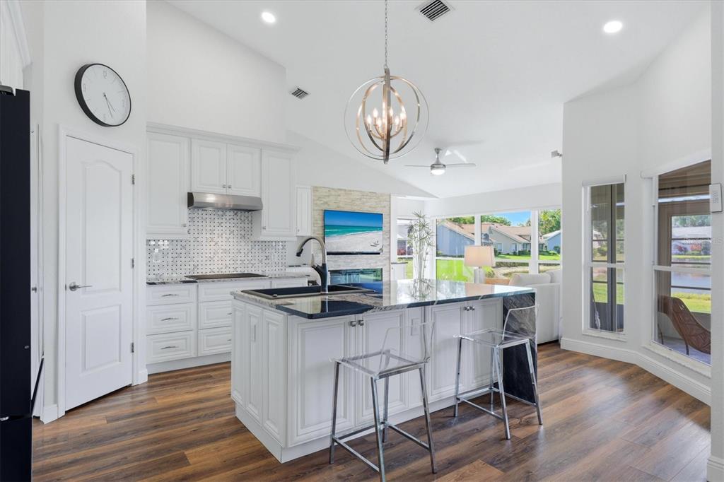 14402 Bridgeview Lane Port Charlotte, FL 33953 - Photo 22 of 93 a kitchen with stainless steel appliances granite countertop a table chairs in it and wooden floors
