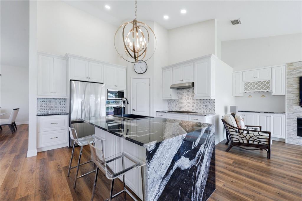 14402 Bridgeview Lane Port Charlotte, FL 33953 - Photo 23 of 93 a kitchen with stainless steel appliances granite countertop a stove a refrigerator and a dining table with wooden floor