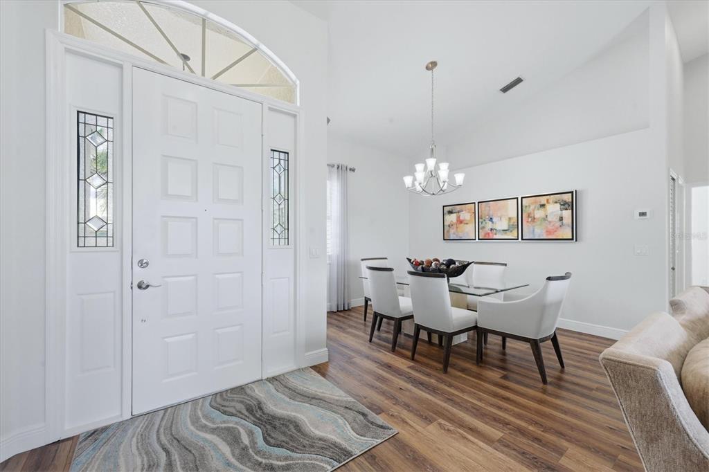 14402 Bridgeview Lane Port Charlotte, FL 33953 - Photo 10 of 93 a dining room with wooden floor a chandelier a wooden table and chairs