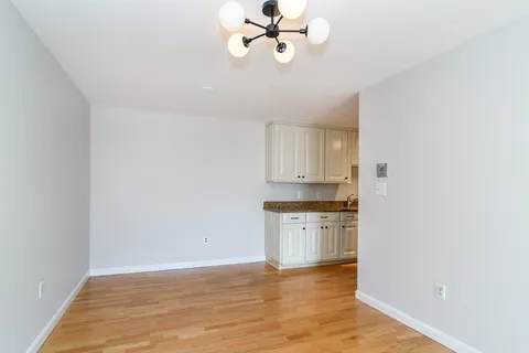 a view of a kitchen with a sink dishwasher and wooden floor