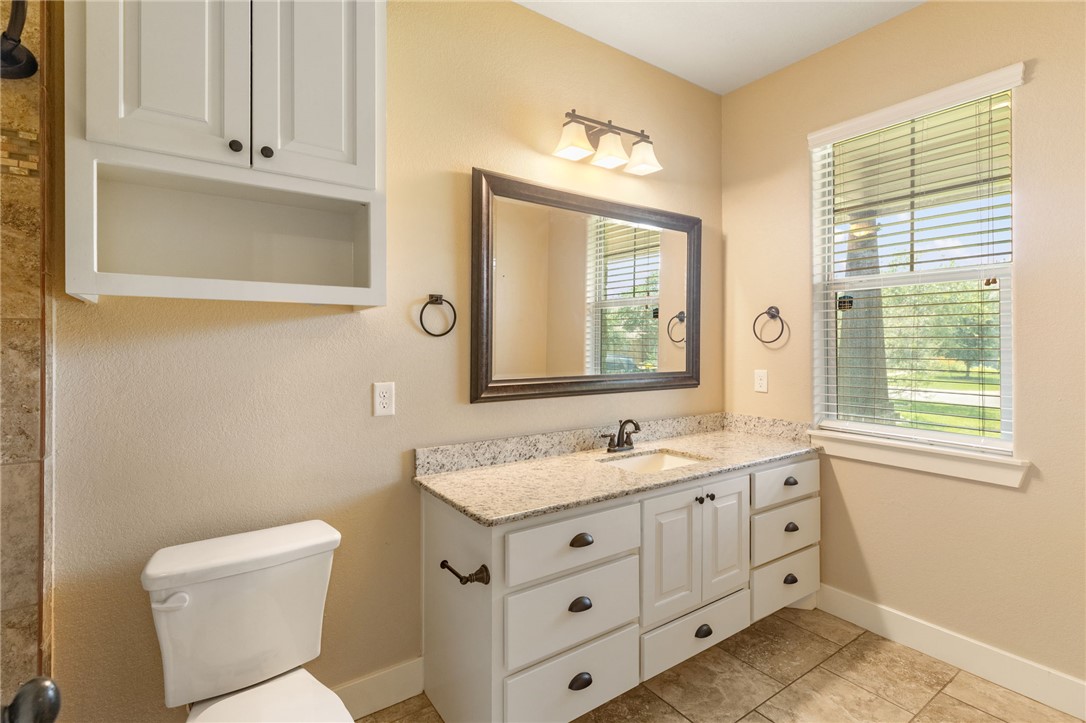 2136 Rockcliffe Loop College Station, TX 77845 - Photo 42 of 48 a bathroom with a granite countertop toilet sink and mirror
