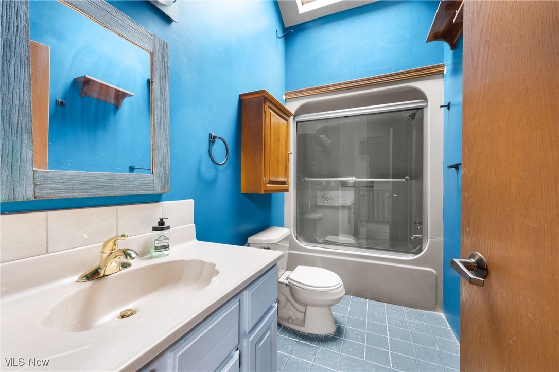 163 Burns Road Elyria, OH 44035 - Photo 23 of 37 Bathroom featuring vanity and shower / bath combination with glass door