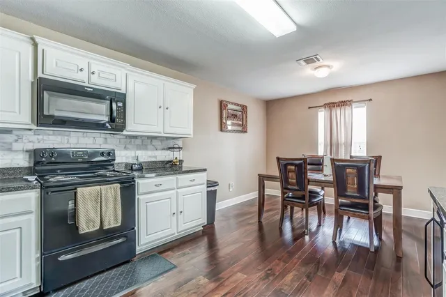 a kitchen with stainless steel appliances wooden floors and wooden cabinets
