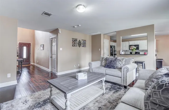 a living room with furniture and a wooden floor
