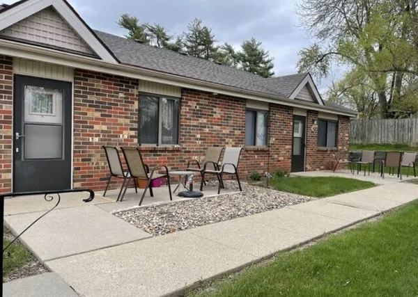 a view of house with backyard and outdoor seating