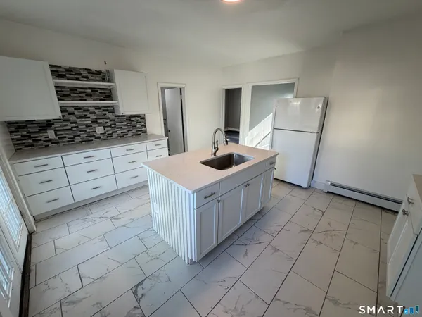 a kitchen with white cabinets and white appliances