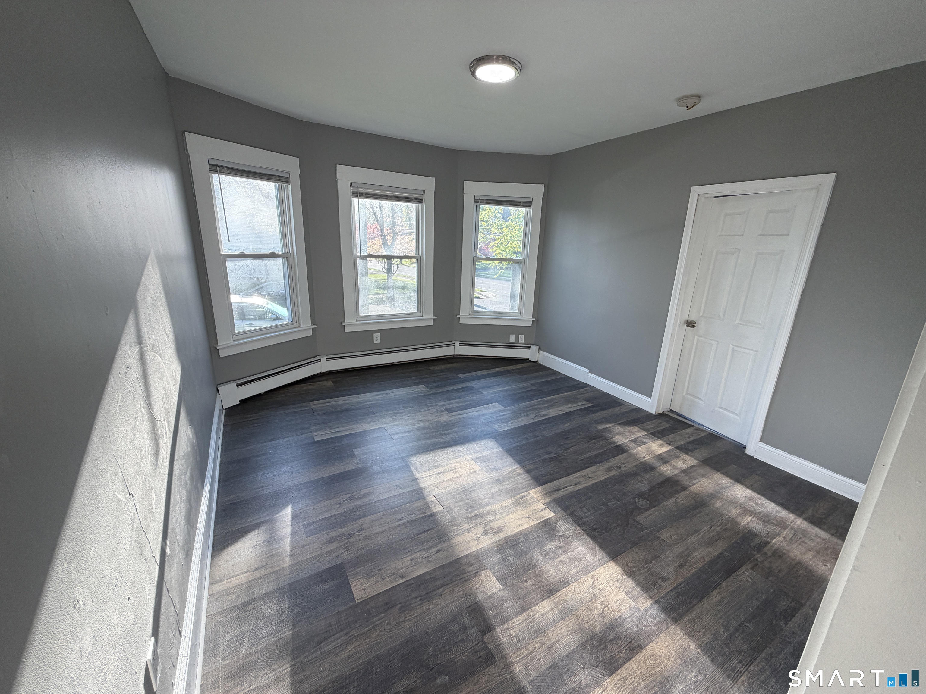 402 Allen Street New Britain, CT 06053 - Photo 6 of 14 an empty room with wooden floor and windows