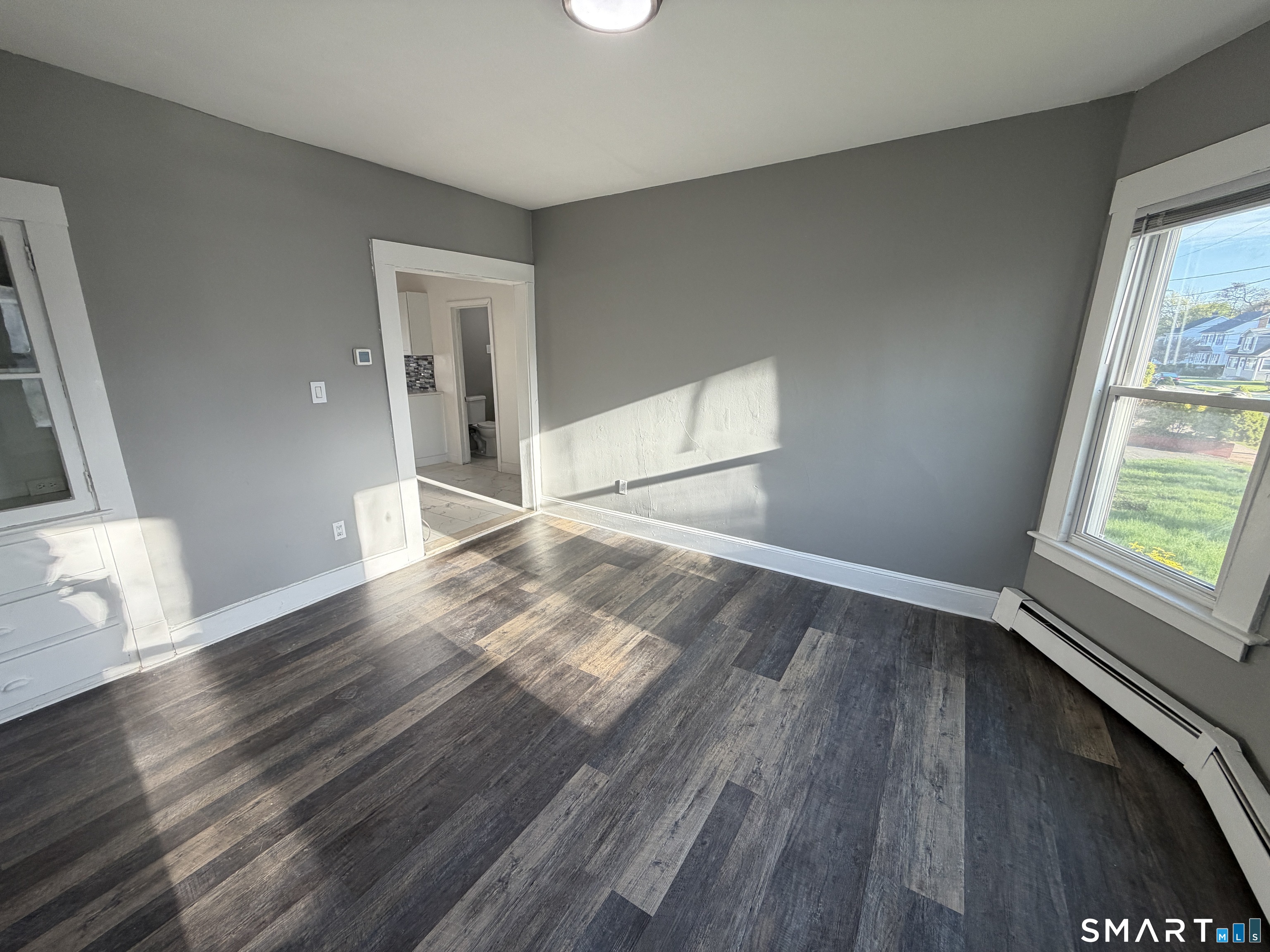 402 Allen Street New Britain, CT 06053 - Photo 8 of 14 a view of an empty room with wooden floor and a window