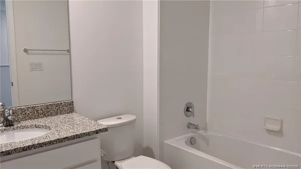 a large kitchen with stainless steel appliances kitchen island granite countertop a refrigerator and a stove top oven