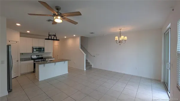 a kitchen with kitchen island white cabinets and stainless steel appliances