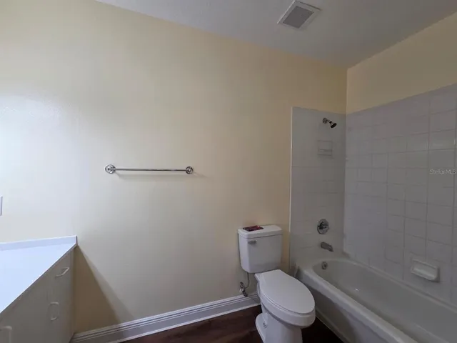 a white toilet sitting next to a bath tub