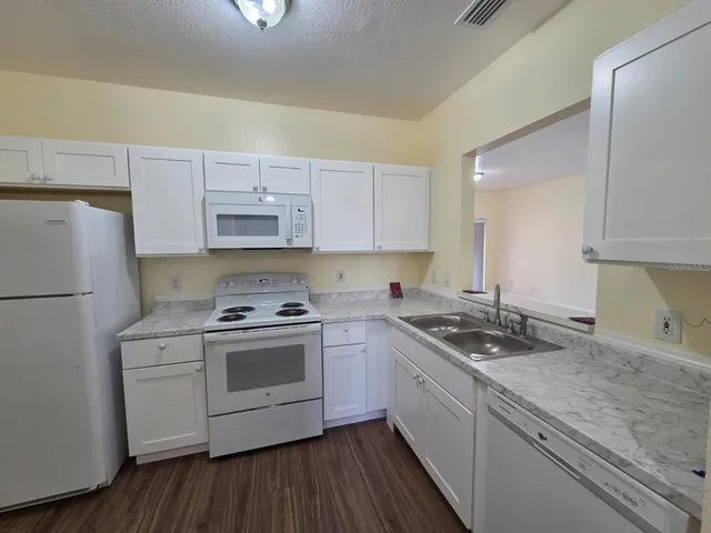 a kitchen with a stove a sink and a refrigerator