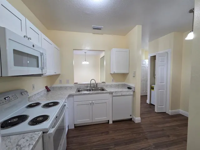 a kitchen with a sink cabinets and wooden floor