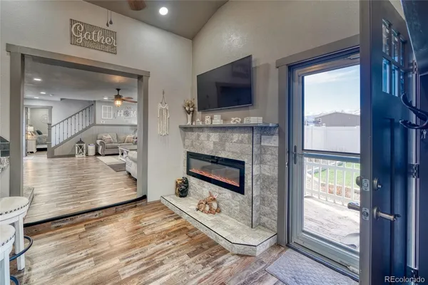 a view of living room kitchen with a flat screen tv and a fireplace