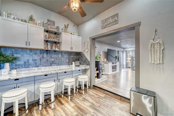 a kitchen with a dining table chairs and white cabinets