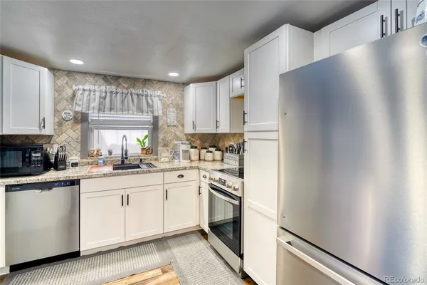 a kitchen with white cabinets and white appliances