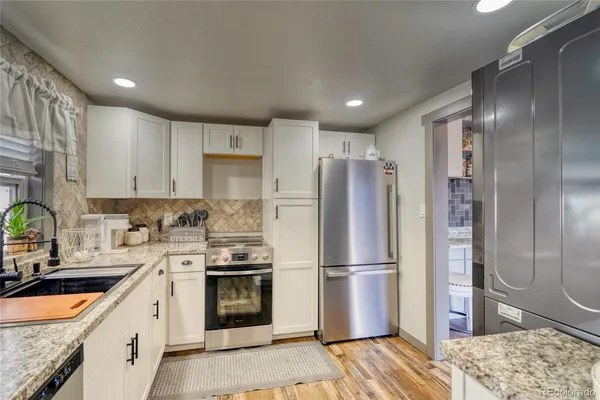a kitchen with a refrigerator sink and cabinets