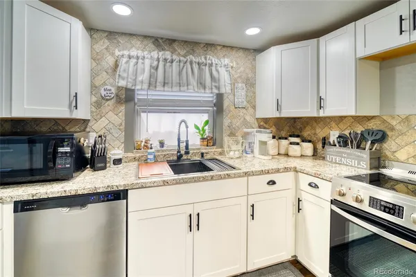 a kitchen with stainless steel appliances granite countertop a sink stove and cabinets