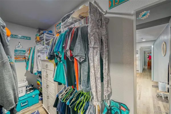 a view of walk in closet with clothes and shoes