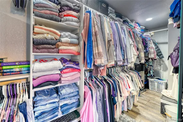 a view of walk in closet with clothes and shoes