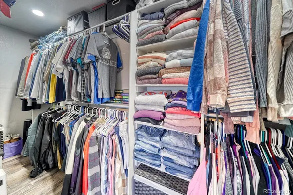 a view of walk in closet with clothes and shoes